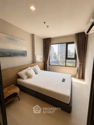 Modern bedroom with city view, featuring a large window, stylish decor, and ample natural light.