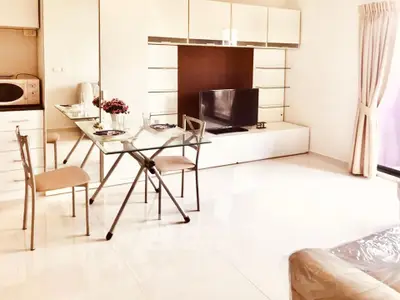 Modern living room with sleek furniture and glass dining table in bright apartment