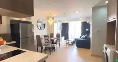 Spacious open-plan living room with modern kitchen and dining area, featuring elegant decor and ample natural light.