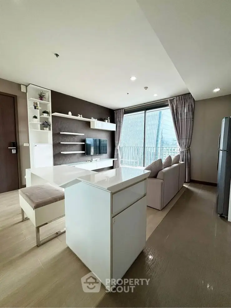 Modern living room with sleek furniture and city view from large windows.
