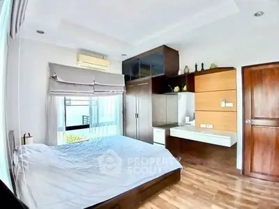 Modern bedroom with wooden flooring and built-in wardrobe, featuring a cozy bed and stylish decor.
