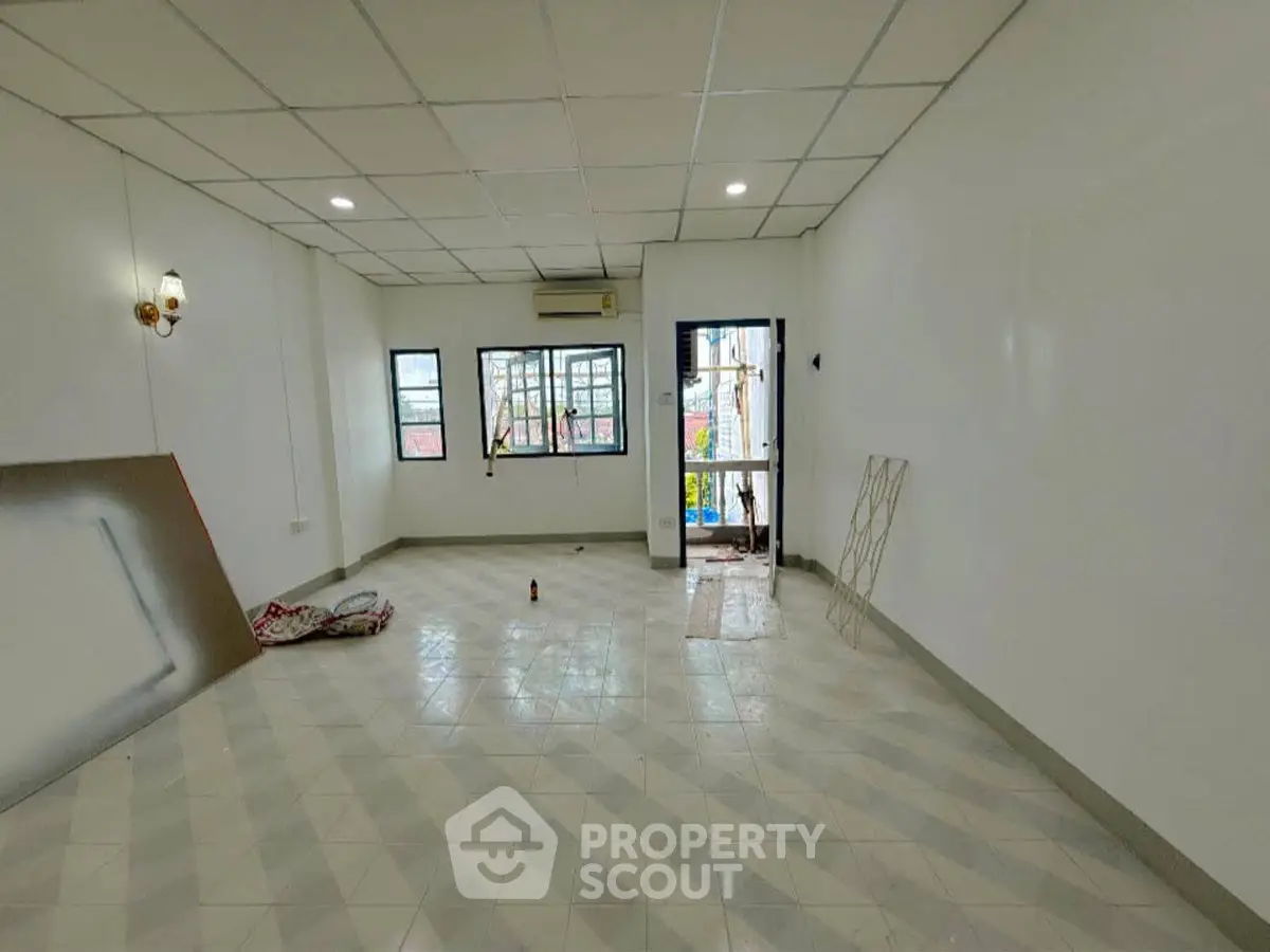 Spacious unfurnished room with tiled flooring and large windows