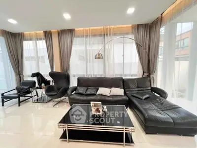 Luxurious modern living room with sleek black leather furniture and elegant decor.