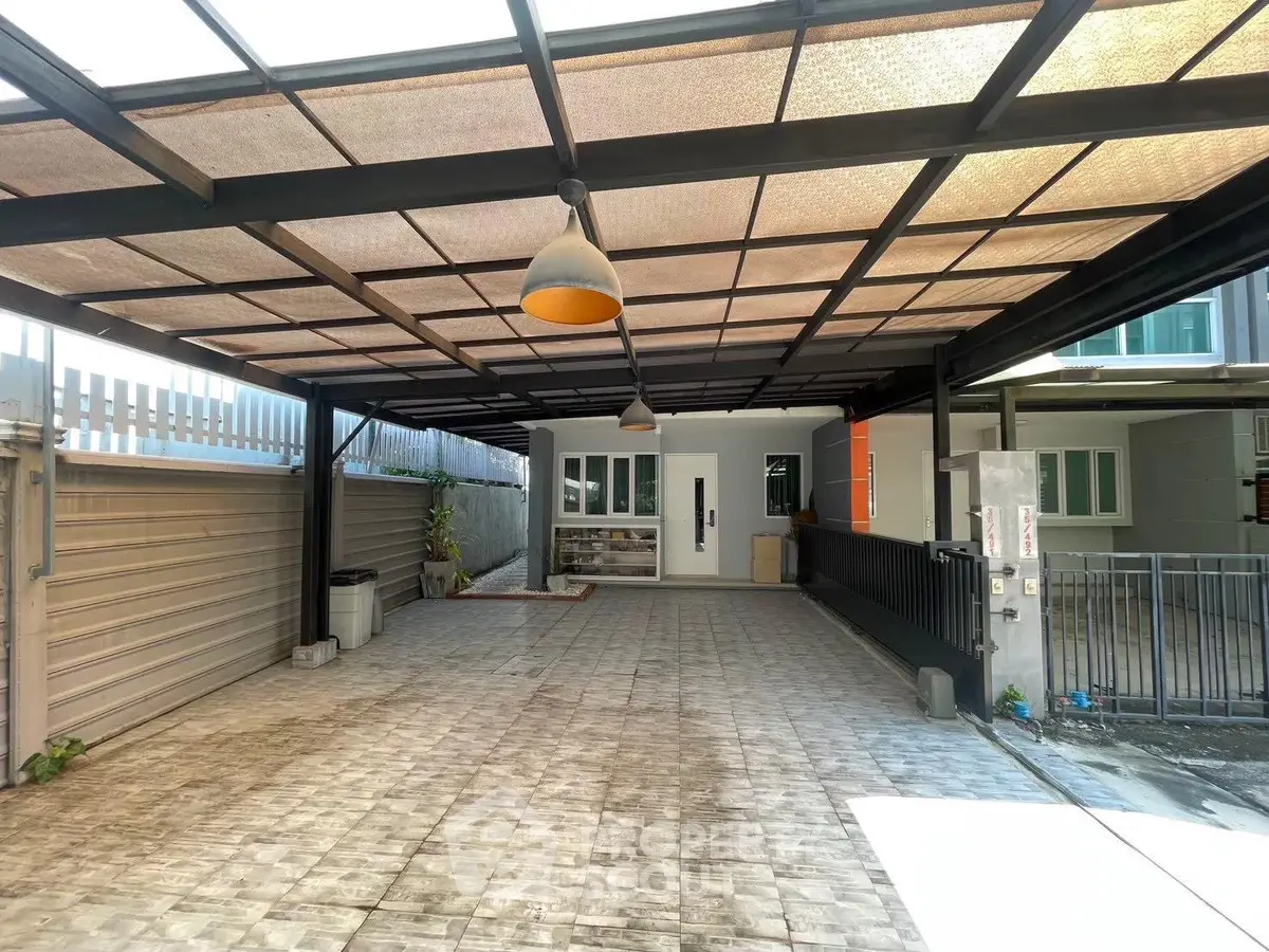 Spacious covered parking area with modern lighting and secure gate access.