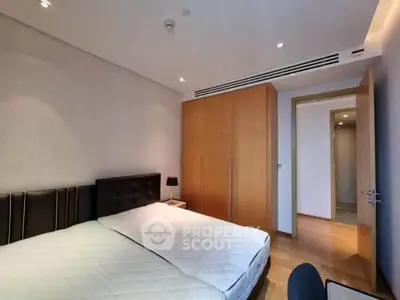 Spacious bedroom with modern design and ample natural light, featuring a large bed and built-in wardrobe.