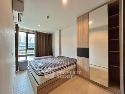 Modern bedroom with large window and stylish wardrobe in urban apartment
