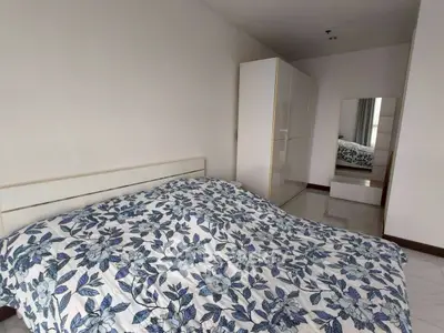 Spacious bedroom with floral bedding and modern wardrobe