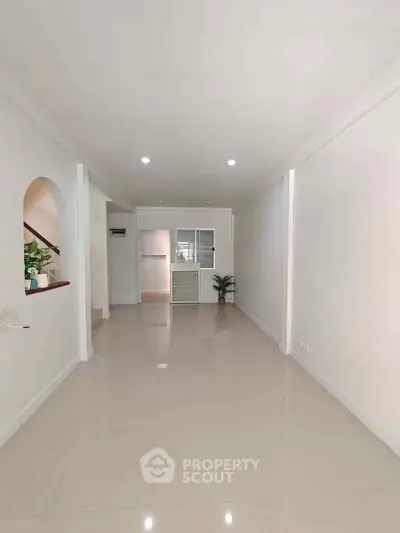 Spacious minimalist living room with sleek tile flooring and modern decor