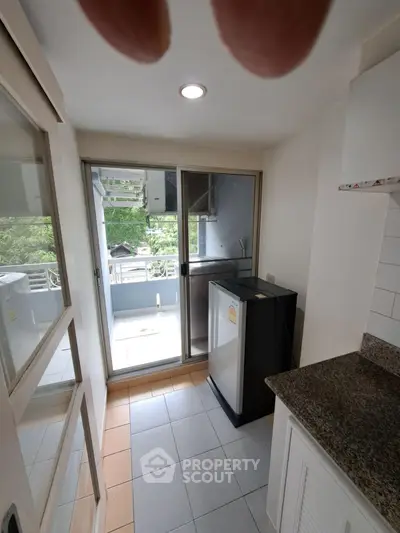 Compact kitchen with balcony access and modern appliances