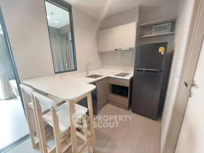 Modern compact kitchen with sleek appliances and breakfast bar in stylish apartment