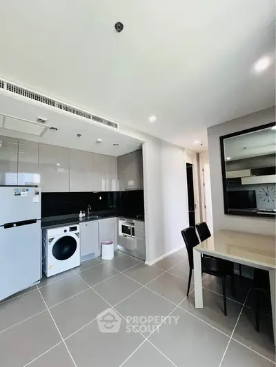 Modern kitchen with sleek appliances and dining area in a stylish apartment