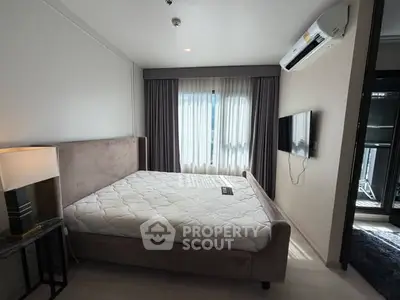 Modern bedroom with large window and air conditioning in stylish apartment.