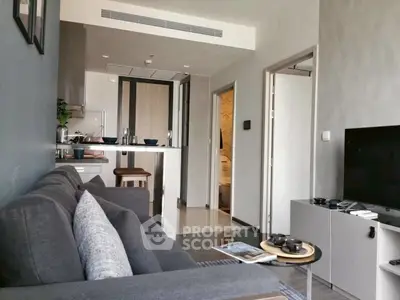 Modern living room with sleek furniture and open kitchen layout in a stylish apartment.