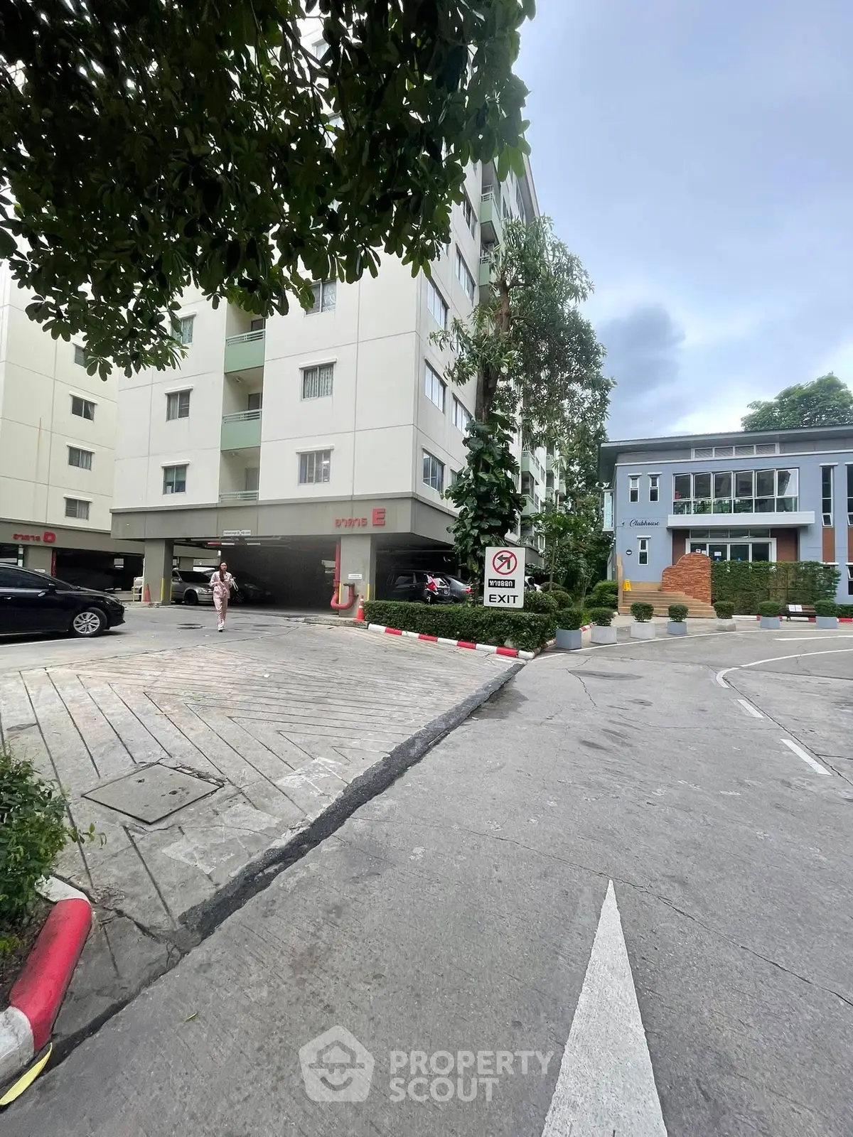 Modern apartment building exterior with parking and lush greenery