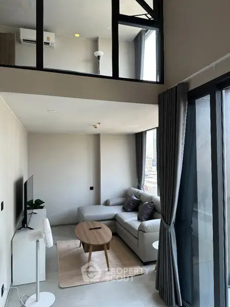 Modern duplex living room with large windows and stylish furniture