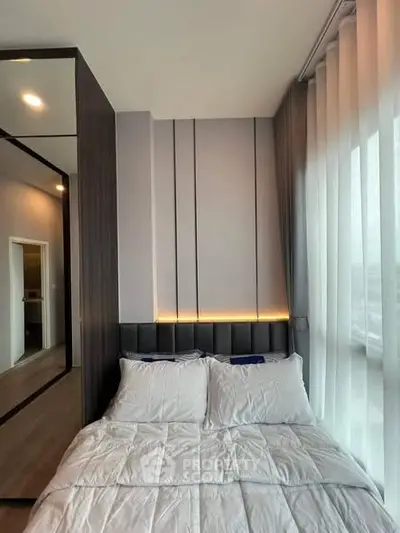 Modern bedroom with cozy bed and stylish lighting in a contemporary apartment.