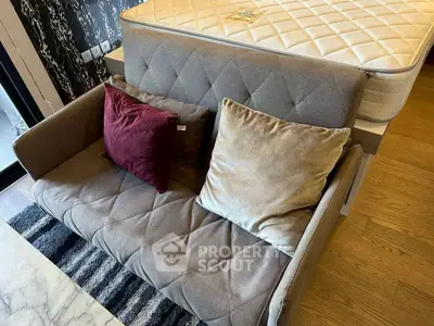 Cozy living room with stylish sofa and plush cushions, perfect for relaxation.