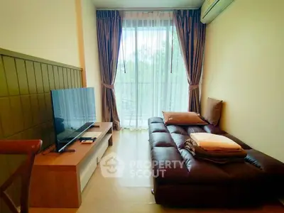Cozy living room with modern sofa and large window offering natural light