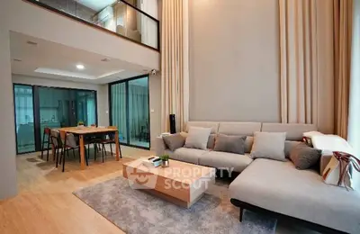 Spacious modern living room with high ceilings and open dining area