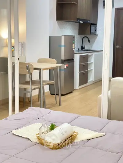 Modern studio apartment with open kitchen and cozy dining area, featuring sleek appliances and stylish decor.