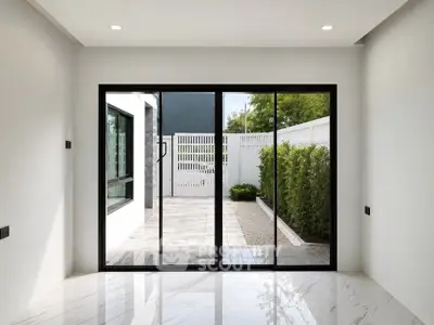 Modern interior with sliding glass doors opening to a private patio and garden area.