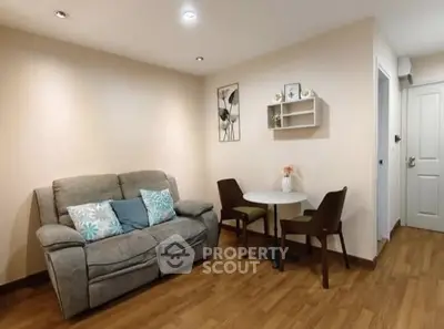 Cozy living room with plush sofa and dining table, perfect for relaxation.