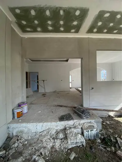 Under-construction interior space with unfinished walls and ceiling, showcasing renovation potential.