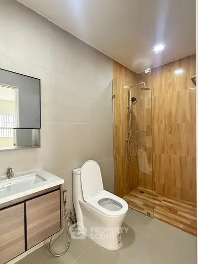 Modern bathroom with sleek design, featuring a glass shower and elegant fixtures.