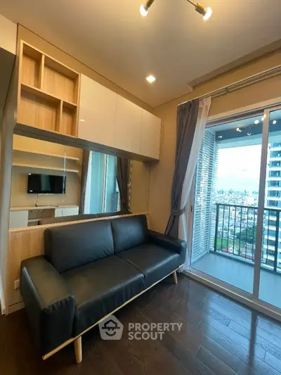 Modern living room with sleek sofa and balcony view in high-rise apartment.