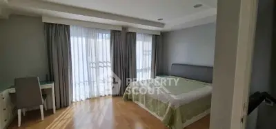 Spacious bedroom with large windows and elegant decor