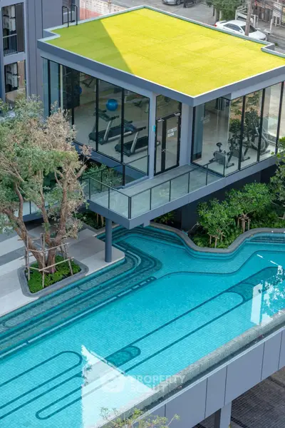 Modern building with rooftop gym and sleek outdoor pool, perfect for luxury living.