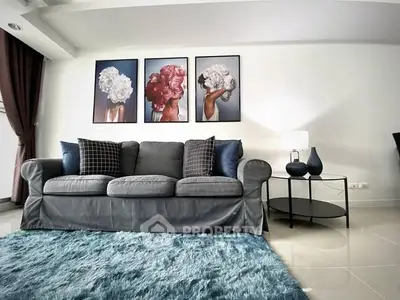 Stylish living room with plush sofa, modern art, and cozy rug in elegant apartment.
