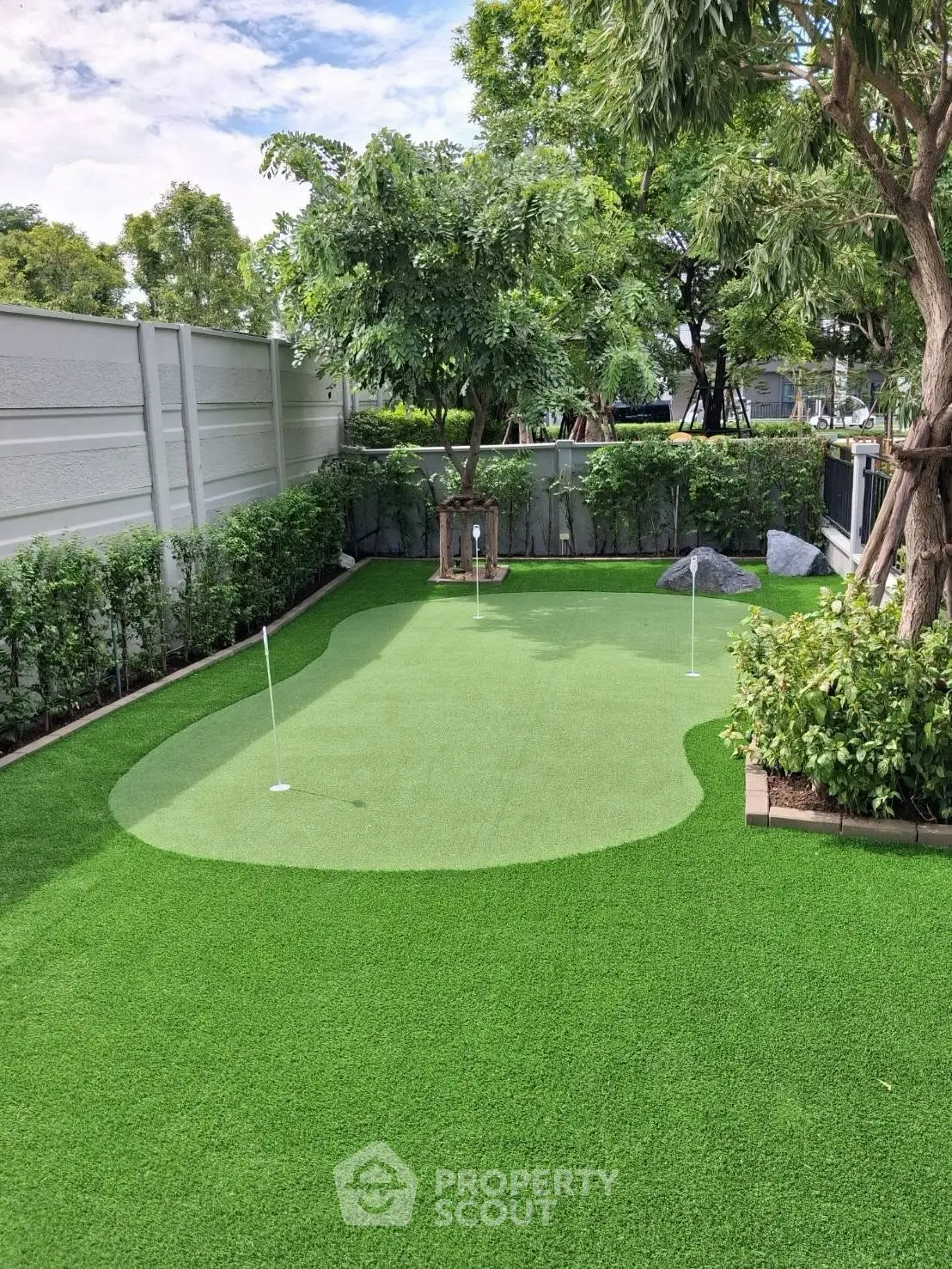 Luxurious backyard with private putting green and lush landscaping, perfect for golf enthusiasts seeking tranquility.