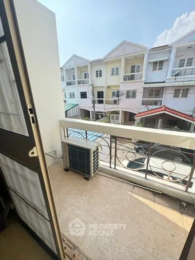 Charming balcony view of a residential street with modern townhouses, perfect for urban living.