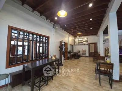 Spacious open-plan living area with wooden accents and modern lighting.