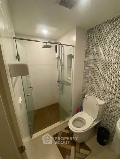Modern bathroom with glass shower enclosure and stylish tile design.