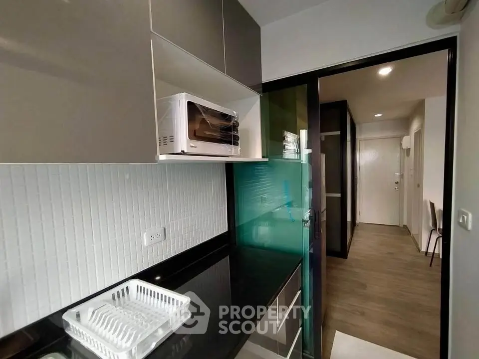 Modern kitchen with sleek cabinetry and microwave in stylish apartment