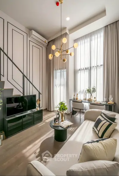 Luxurious modern living room with high ceilings, elegant chandelier, and stylish decor.