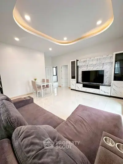 Modern living room with stylish marble TV wall and cozy seating area.