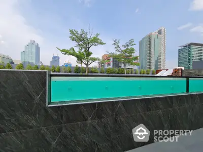 Modern rooftop pool with city skyline view and lush greenery