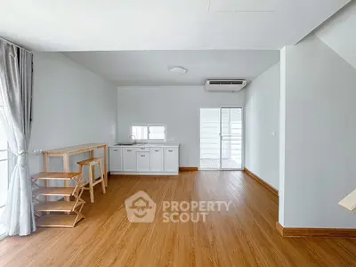 Spacious modern living room with wooden flooring and natural light