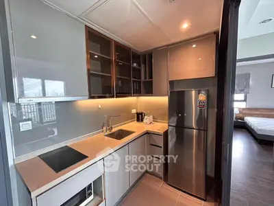 Modern kitchen with sleek cabinetry and stainless steel appliances in a stylish apartment.