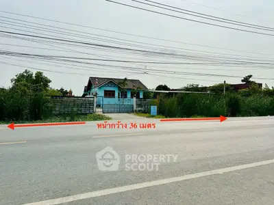 Charming blue house with spacious front yard and lush greenery, ideal for serene living.