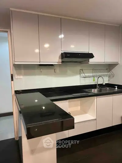 Modern kitchen with sleek black countertops and white cabinets