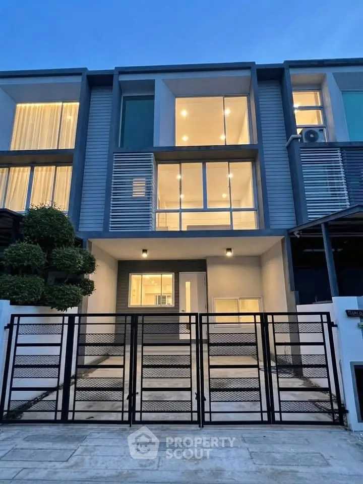 Modern townhouse exterior with sleek design and large windows at dusk.