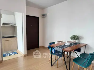 Modern dining area with wooden table and chairs adjacent to compact kitchen in cozy apartment.