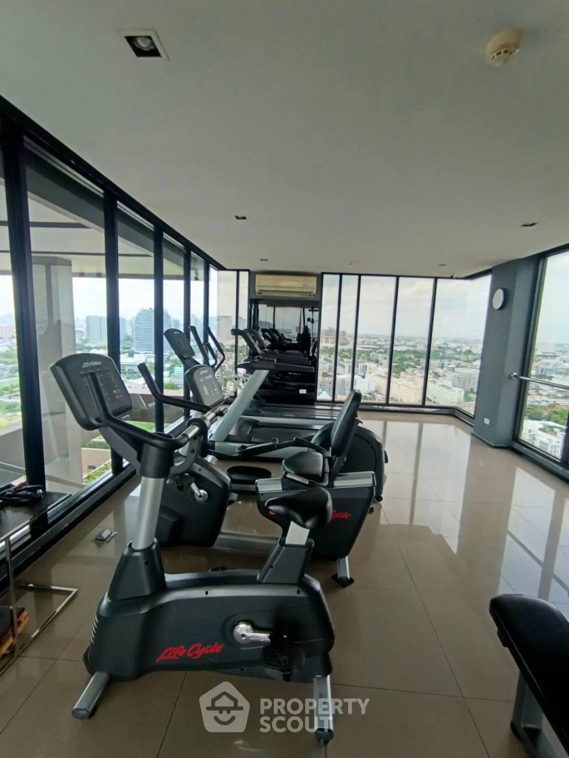 Modern gym with panoramic city views and state-of-the-art equipment.