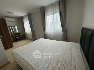 Spacious bedroom with modern furnishings and natural light