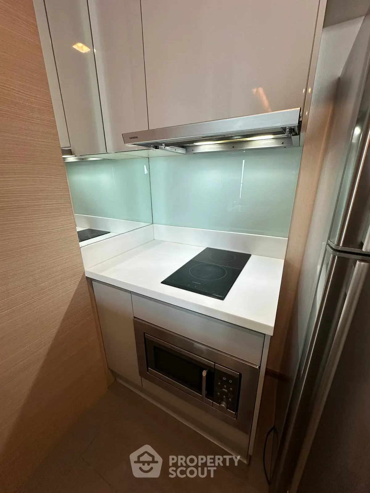 Modern compact kitchen with sleek appliances and induction cooktop
