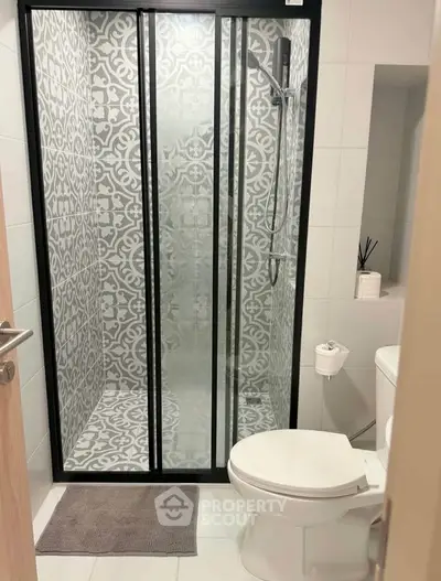 Modern bathroom with stylish patterned shower and sleek fixtures